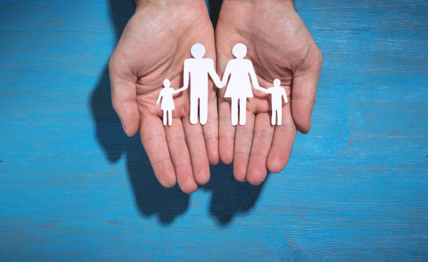 istock Human hands showing paper cut family. 1347829004