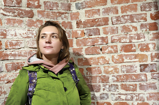 Portrait of woman on background of old brick wall