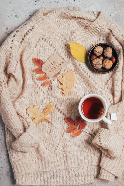 istock Flat lay with cup of tea, note with text hello aututmn colorful autumn leaves, nuts on sweater. 1347830191
