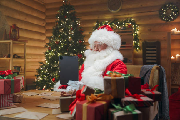 istock Santa Claus is having a video chat on his digital tablet while sitting in his office 1347837440
