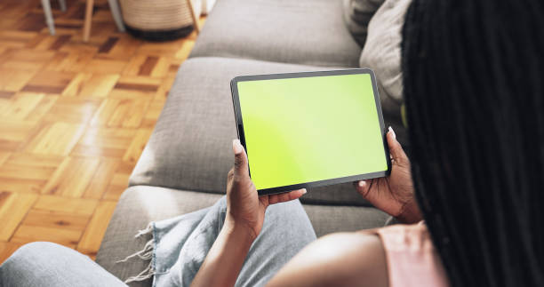 Shot of a unrecognizable woman using her tablet at home stock photo