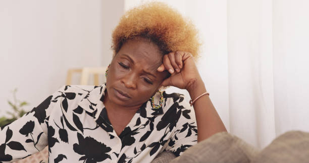 Shot of a mature woman being stressed on the couch at home Life's ups and downs woman defeat stock pictures, royalty-free photos & images