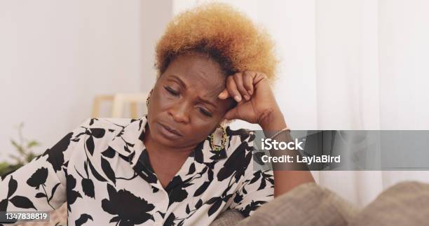 Shot Of A Mature Woman Being Stressed On The Couch At Home Stock Photo - Download Image Now