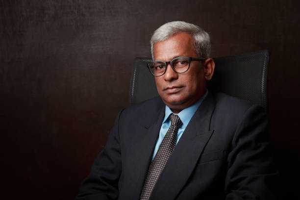 オフィスの椅子に座るインドの民族のビジネスマンの肖像画 - senior manager ストックフォトと画像