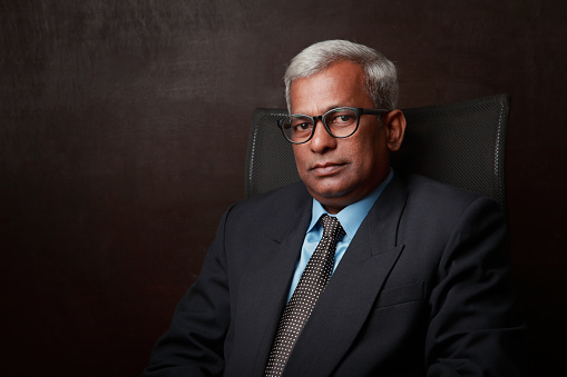 Portrait of a business man of Indian ethnicity sitting on his office chair
