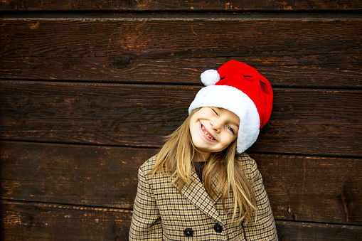 Portrait of little silly girl wearing santa hat