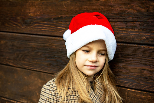 Sad little girl with santa hat, outdoor