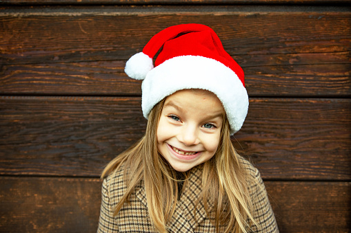 Portrait of little silly girl wearing santa hat