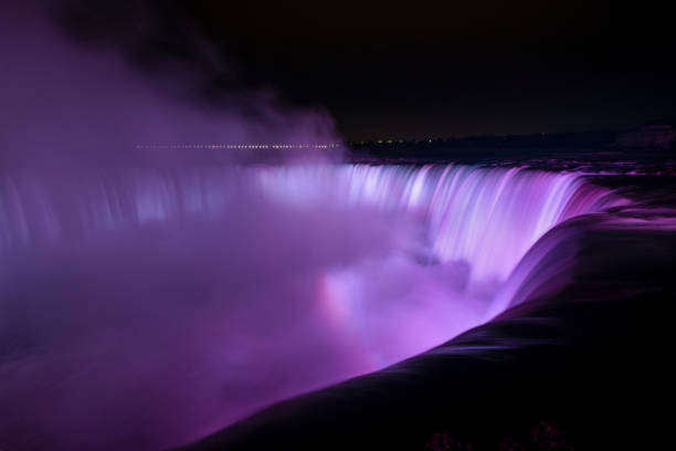 istock Niagara Falls illuminated in purple light with rainbows from the mist, Canada. 1347844661