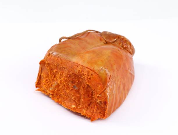 nduja, à l’intérieur de son boyau de saucisse, sur fond blanc. c’est une saucisse de porc traditionnelle épicée et tartinable d’italie - casing photos et images de collection