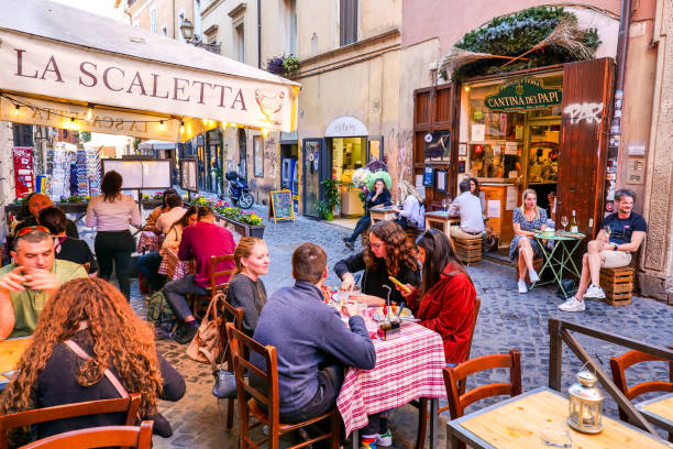 dezenas de clientes curtem a vida em um típico restaurante trastevere no coração histórico de roma - brick wall paving stone brick wall - fotografias e filmes do acervo