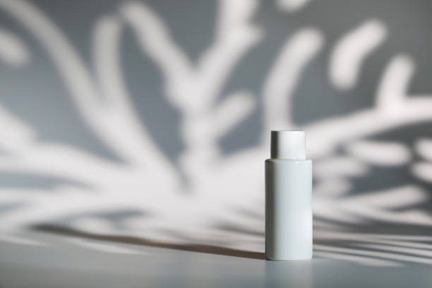 istock Blank white plastic bottle of cosmetic product on table against shadows space for design 1347845819