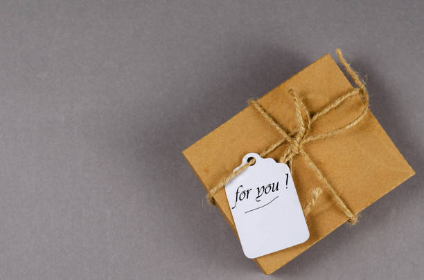 istock Brown gift box on gray background. Cardboard box tied with twine 1347845963