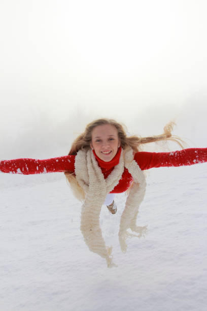 Blonde woman warming hands with warm breath.Close up woman jogging in sports warm clothes. Stylish girl in cold day outdoors