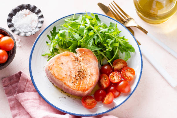 gebratenes thunfischsteak mit rucola - plate food fusion food color image stock-fotos und bilder