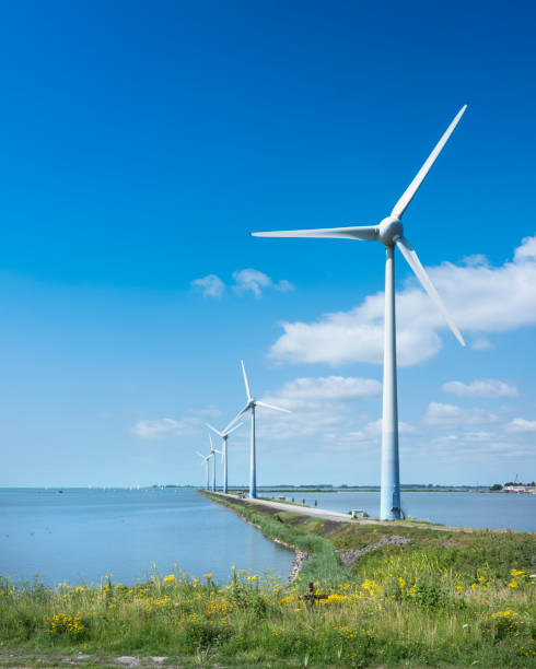 wind turbines near enkhuizen in holland under blue summer sky wind turbines on dike near enkhuizen in the netherlands under blue summer sky enkhuizen stock pictures, royalty-free photos & images