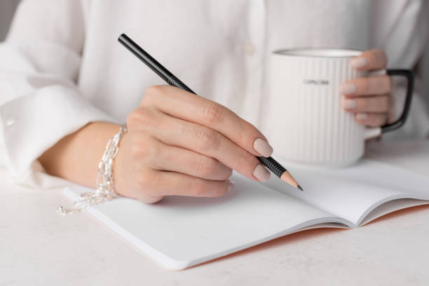 istock woman writing in notepad placed on white desk 1347851269