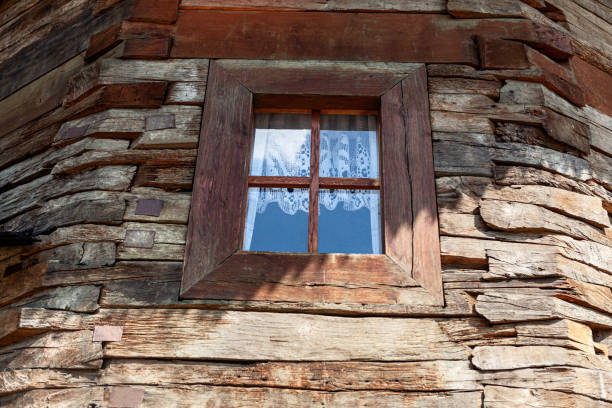 Rustic house made by wooden beams . Window and wooden wall