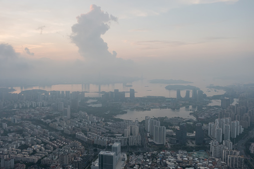 The city skyline of Xiamen, China at dawn, shrouded in fog and clouds