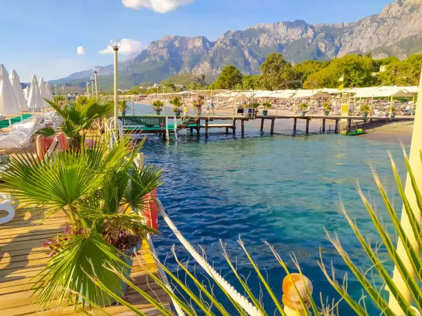 Sea coast with the resort piers and mountains at the background in Kemer, Goynuk, Turkey