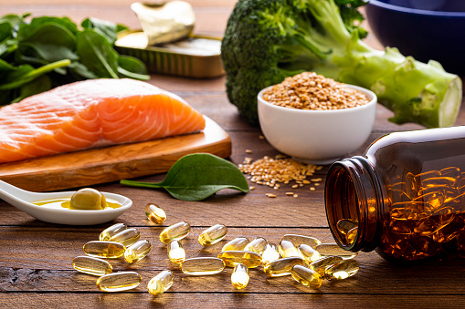 Healthy food products. Balanced nutrition. Salmon fish, beef, beans, nuts and vegetables with olive oil. Top view image at white table.