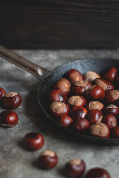 istock Ripe chestnuts in an old iron pan. 1347857968