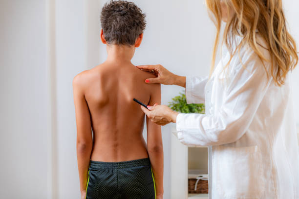 médico pediatra examinando la postura de un niño, haciendo marcas en su espalda, verificando el ángulo de los huesos de la escápula. - escapula fotografías e imágenes de stock
