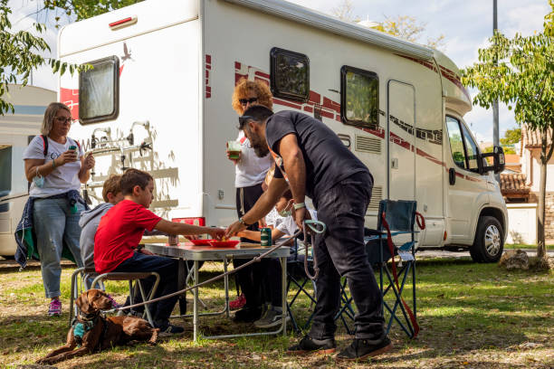 A family with children having a snack next to their motorhome at a service area stock photo