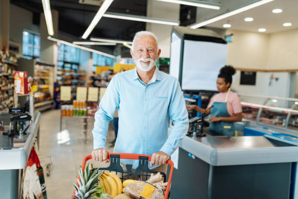 istock Smiling senior man buying groceries and looking at camera 1347861656