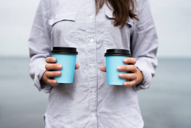 istock Two coffee in paper cups in woman hands 1347862055