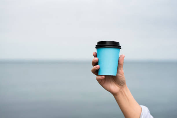 istock Woman holding in hand a coffee in paper cup 1347862061