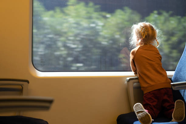 istock Little girl watching window while travelling by train. Public transportation 1347863816