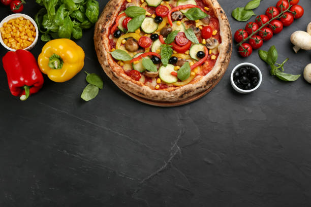 istock Flat lay composition with delicious hot vegetable pizza on black table. Space for text 1347868738