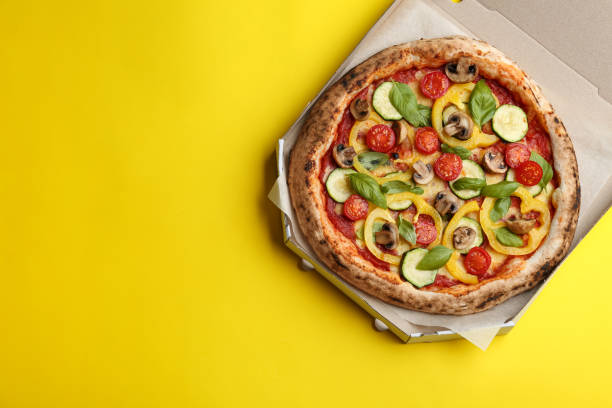 deliciosa pizza de verduras en caja de cartón sobre fondo amarillo, vista superior. espacio para texto - vegetarian pizza fotografías e imágenes de stock