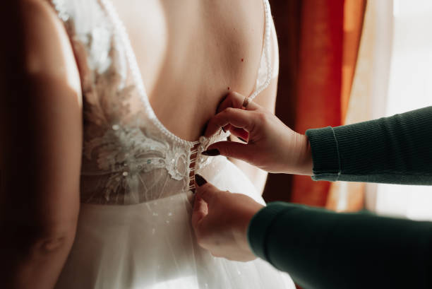 istock bride in white dress put on dress back view 1347870019