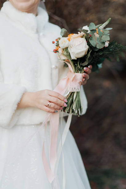 istock bride in a white fur coat holds her wedding bouquet in her hands 1347870048