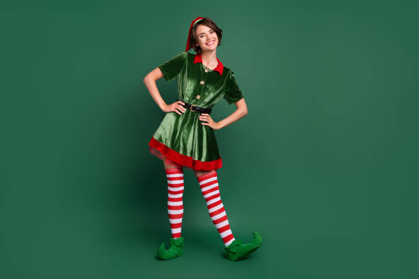 Photo of funny positive cheerful helper lady hands hips wear elf costume hat stockings isolated green color background stock photo