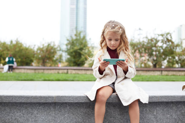 istock Funny child with long hair holding a mobile 1347879625