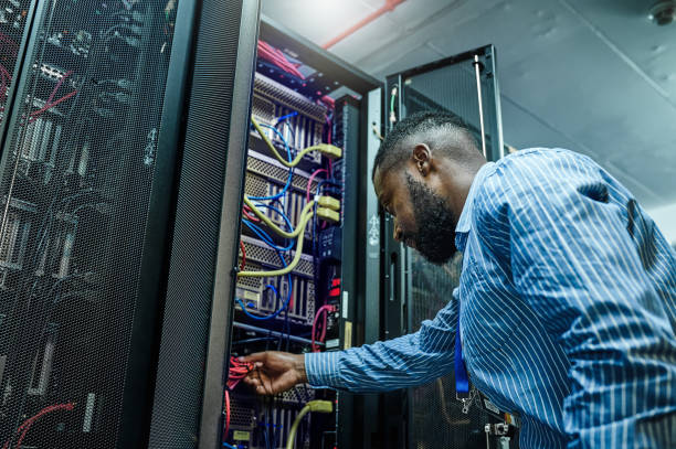 istock Shot of a young man working in a server room 1347879809