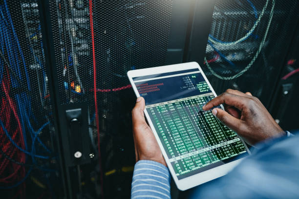 istock Shot of a young man using a digital tablet while working in a server room 1347879959