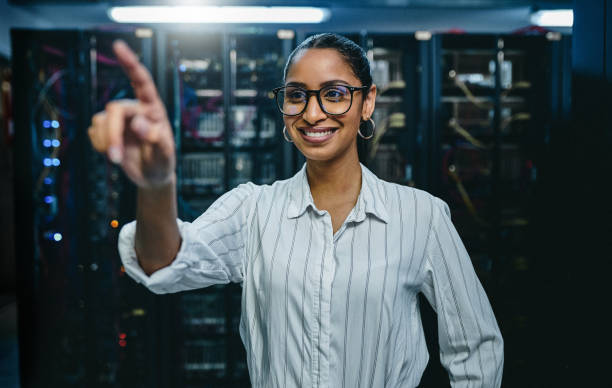 istock Shot of a young woman connecting to a user interface in a server room 1347879987