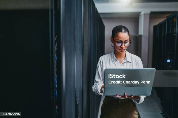 Shot Of A Young Woman Using A Laptop While Working In A Server Room Stock Photo - Download Image Now