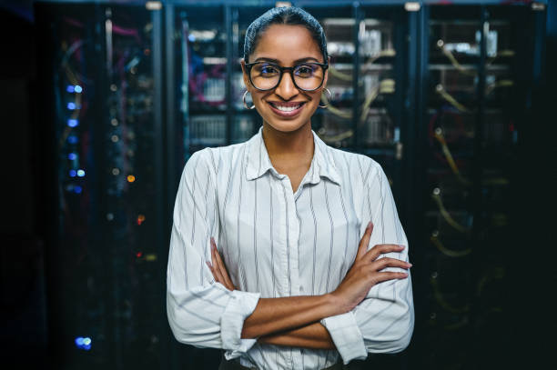 retrato de uma jovem de pé com os braços cruzados enquanto trabalhava em uma sala de servidor - data center computer programmer women - fotografias e filmes do acervo