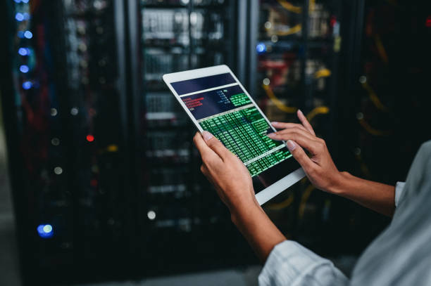 istock Shot of a young woman using a digital tablet while working in a server room 1347880110