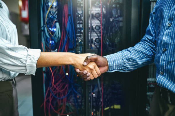 istock Closeup shot of two unrecognisable technicians shaking hands in a server room 1347880344