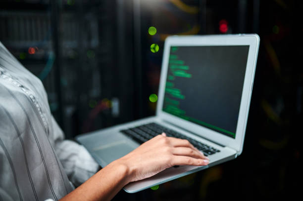 istock Closeup shot of an unrecognisable woman using a laptop while working in a server room 1347880362