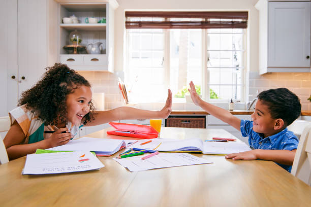 istock Shot of two siblings high fiving each other while doing homework 1347881805