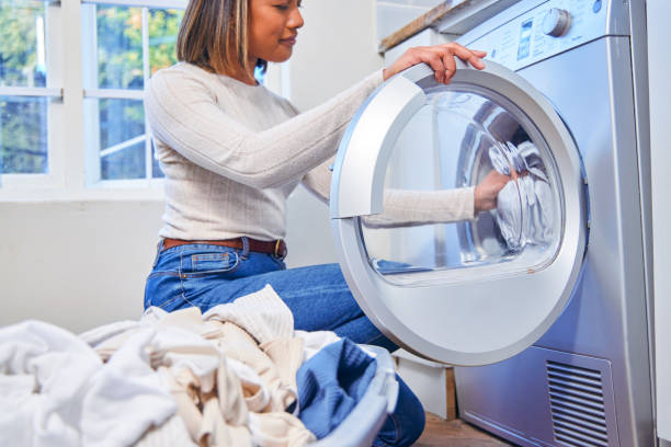 istock Shot of a woman loading laundry into her washing machine 1347881881