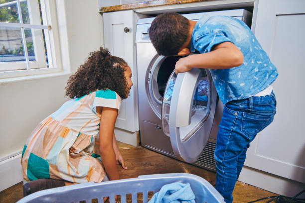 istock Shot of tow siblings peeking inside their washing machine 1347882858