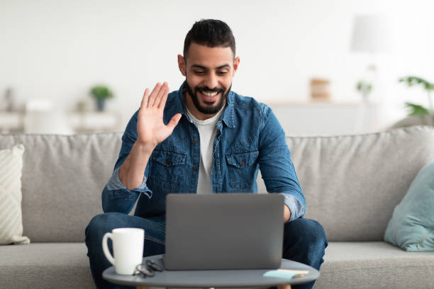 istock Online meeting. Happy young Arab man using laptop computer for conferencing, having video call at home 1347884830